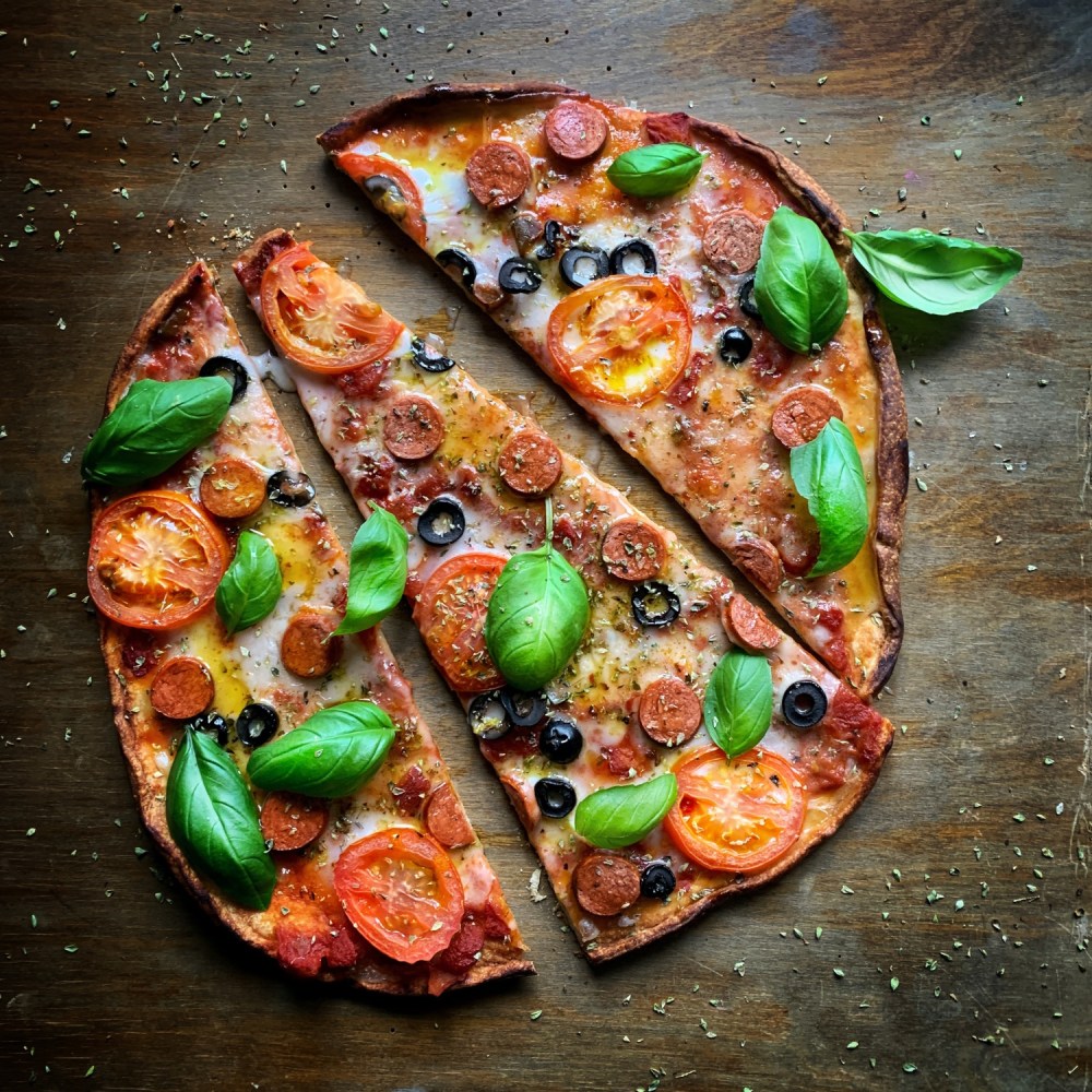 Vegan pizza with tomatoes and basil and plant-based meat and cheese