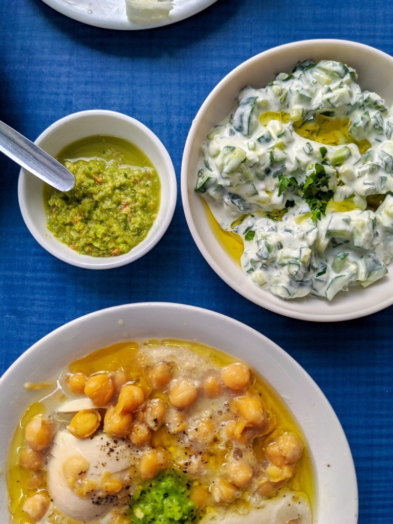 Bowls of vegan food including chickpeas and plant-based tzatziki