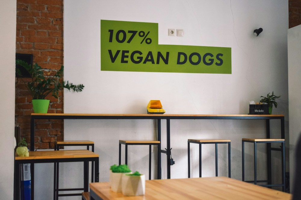 An empty restaurant with the text 107% vegan dogs on the wall